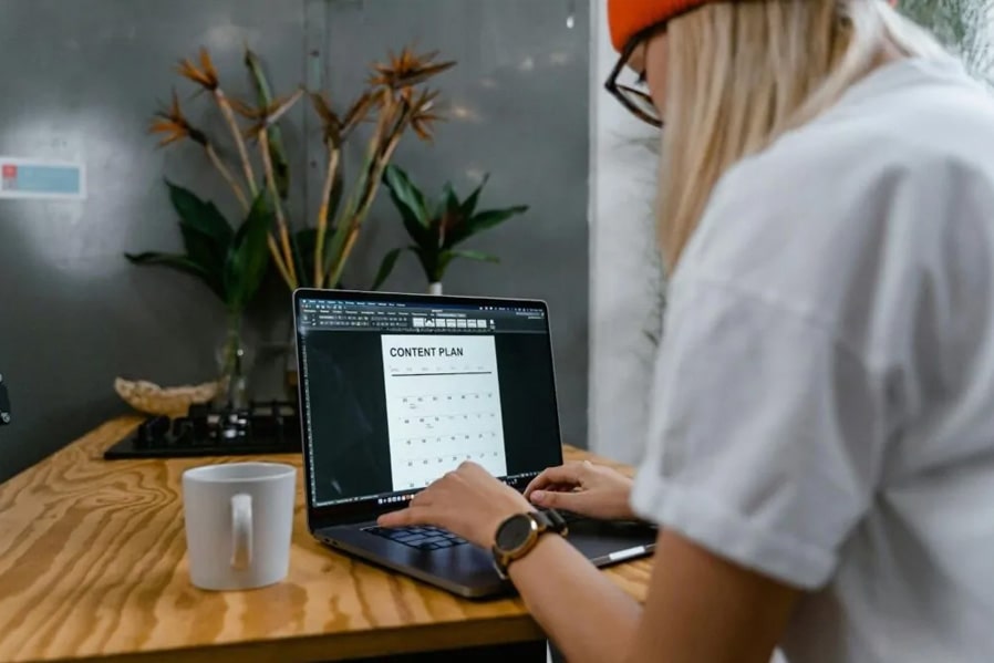 woman in white shirt with laptop